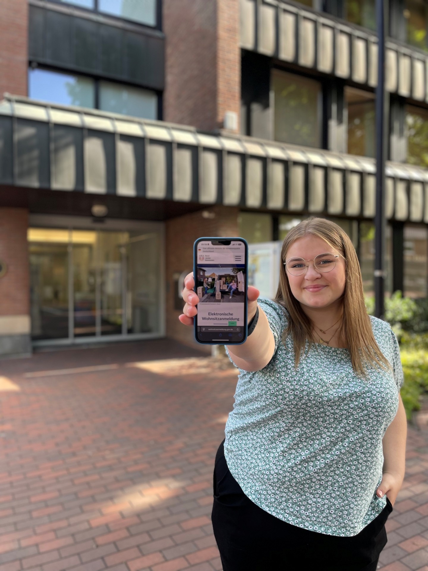 Bild Mitarbeiterin vor dem Rathaus